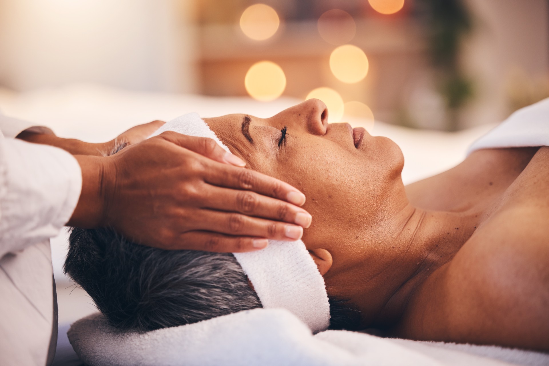 Wellness, Gesundheit und Massage, ältere Frau in einem Spa, die luxuriöse Schönheitstherapie und Gesichtsbehandlung erhält. Reife schwarze Frau, Zen und Masseurin massieren Öl auf dem Kopf, um Körper und Geist zum Stressabbau zu entspannen.